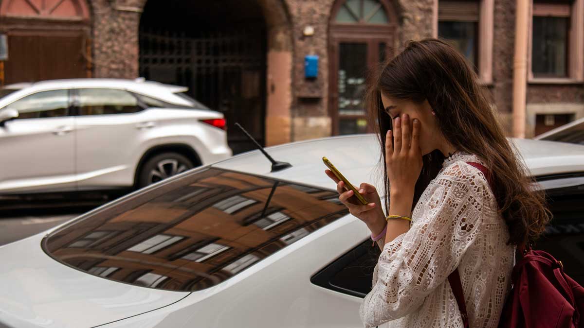 Zatpark - Fleet parking ticket management - person checking their mobile next to a parked car