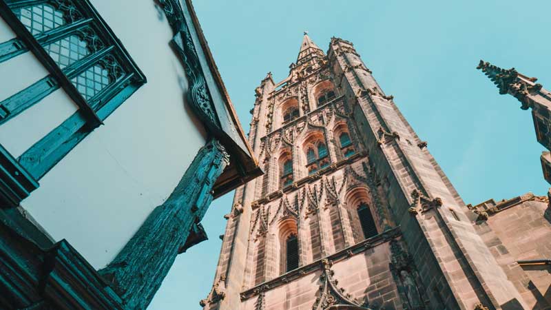 Coventry cathedral from the ground looking up at the steeple with tudor house in the foreground