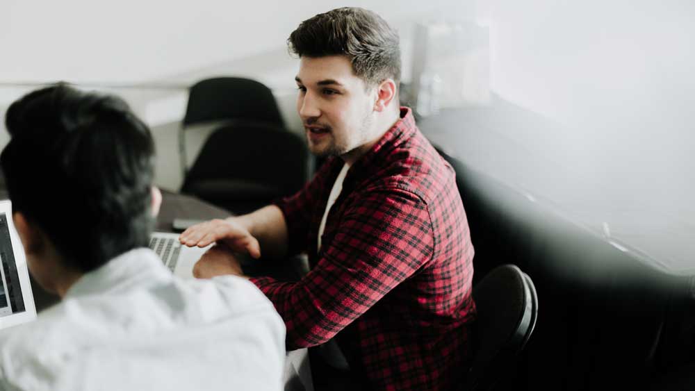 Unity5 Customer Service Customer technical team - two men talking at laptops - Photo: priscilla du preez